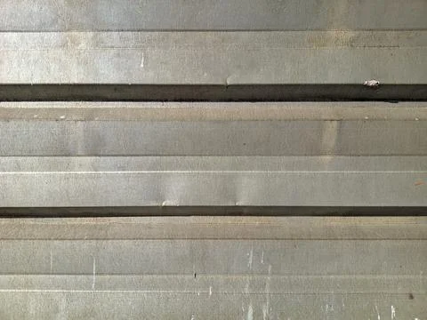 Weathered Gray Metal Wall Texture with Horizontal Panels and Surface Marks 库存照片