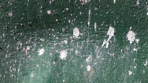 Weathered green surface with white paint splatters and cracks Stock Photos