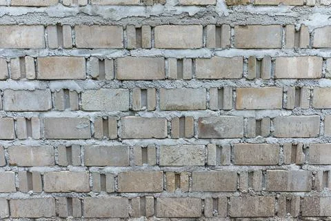 Weathered grey brick wall texture with concrete mortar joints and surface p.. Stock Photos