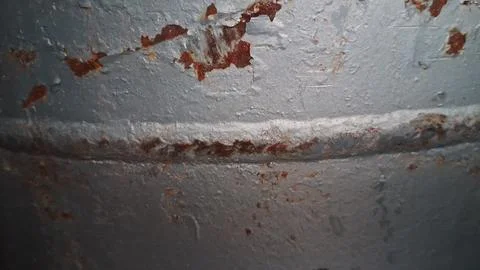 Weathered grey metal surface featuring rough texture and orange rust Stock Photos