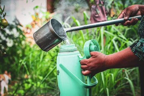 Weathered hands pouring steaming hot water Stock Photos