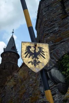 A weathered heraldic shield with a black eagle emblem attached to a pole a... Stock Photos