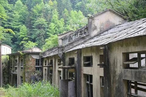 Weathered hillside building row with sagging tiled roofs and empty window o.. Stock Photos
