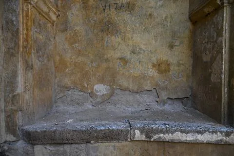 Weathered historic plaster wall with peeling texture and aged graffiti insi.. Stockfoto's