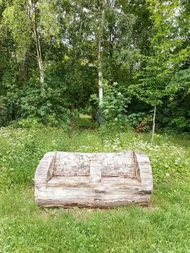 Weathered log sofa in forest clearing Stockfoto's
