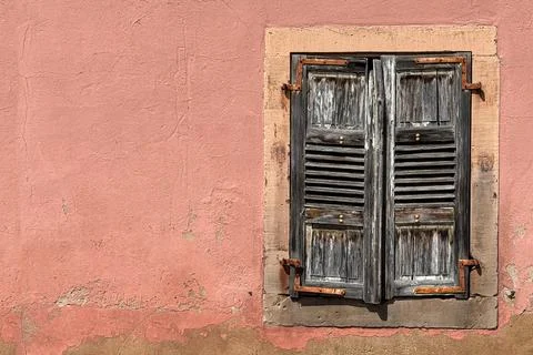 Weathered louvered window shutters create interesting European still life sce Stock Photos