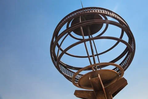 A weathered metal globe shaped object featuring interconnected rings Stock Photos
