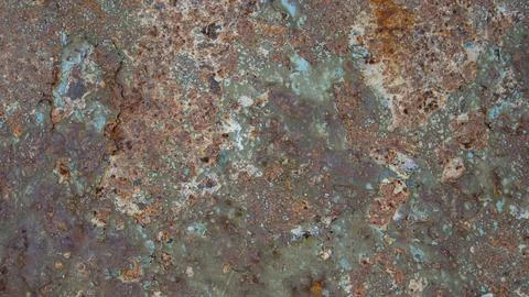 Weathered metal sheet shows rust, corrosion, and peeling paint in teal tone.. Photos