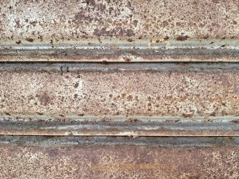 Weathered metal shutter layers showing rusted texture and dark organic sedi.. Stock Photos