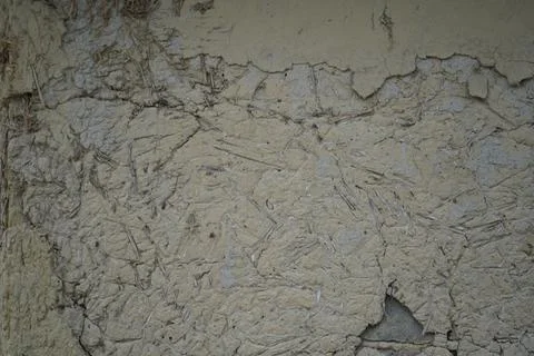Weathered mud wall texture with cracks and peeling plaster surface background Stock Photos