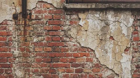 Weathered old brick wall with peeling plaster. Fotos Stock