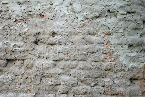 Weathered old rustic wall, peeling plaster and exposed brick. Stock Photos