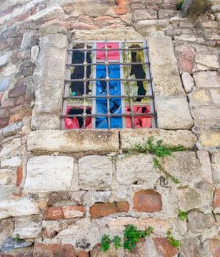 Weathered old stone bricks wall with corroded antique grunge wrought iron window Stock Photos