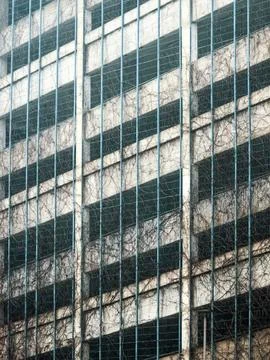 Weathered parking structure facade with vines Stock Photos