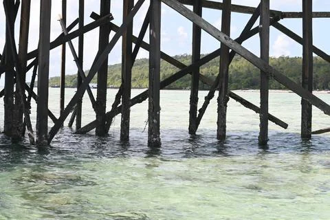 Weathered pier structure in clear turquoise ocean water Stock-Fotos