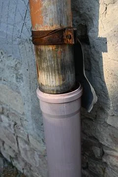 Weathered pipe connection on a masonry wall Фото