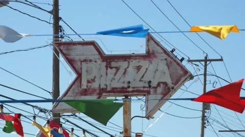 Weathered pizza arrow sign with triangular pennant banners. 4k60p Stock Footage 133378816