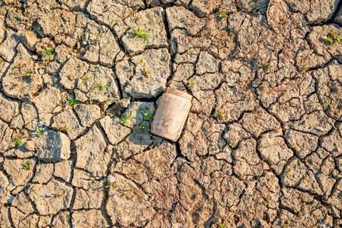 Weathered plastic can littering an arid, parched landscape. Concept of envi.. Stock Photos