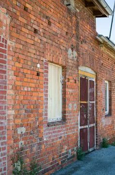 Weathered red brick building facade. Stock Photos