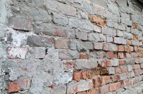 Weathered red brick wall background with spots Stock Photos