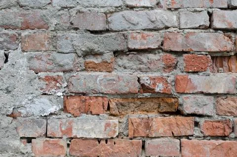 Weathered red brick wall background with spots Stock Photos