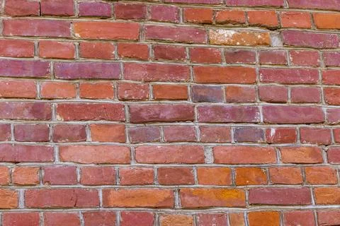 Weathered red brick wall surface in a perspective side angle view. Background Stock Photos