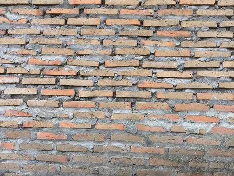 Weathered red bricks line a rustic wall Fotos de archivo