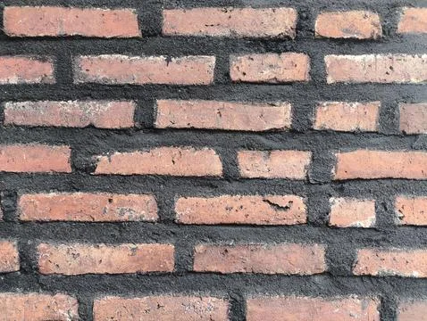 Weathered red bricks line a rustic wall Stock-Fotos