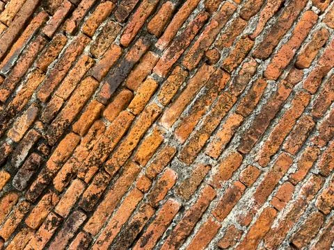 Weathered Red Clay Bricks Arranged In Diagonal Pattern On Ancient Wall Stat.. Foto stock