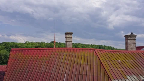 Weathered Red Rooftop with Chimneys Against Forest and Sky Stock Footage 313882374
