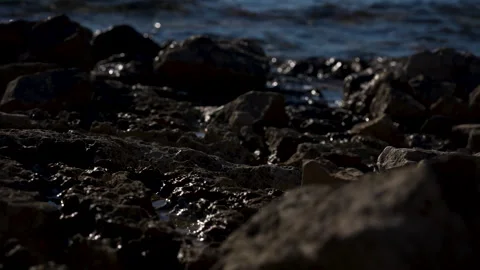 Weathered Rocks Overlooking Choppy Blue Water Stock Footage 341630179