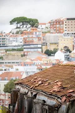 Weathered rooftop structure overlooking Lisbon hillside Stock Photos