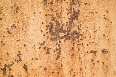 Weathered rough yellow  painted surface with patterns of cracks and peeling.. Foto stock
