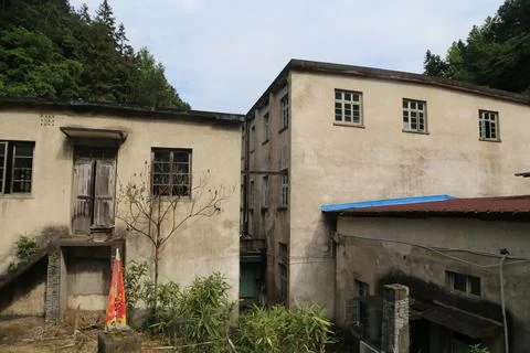 Weathered rural building complex with red door decoration and blue roof awn.. Stock Photos
