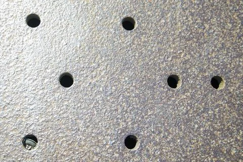 Weathered rusty iron plate with perforated hole pattern 库存照片