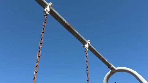 Weathered, rusty swing chains creak as they sway back and forth. The 库存影片 332779531