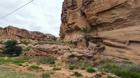 Weathered sandstone cliffs rise beside the road to Uplistsikhe in Georgia Stock Footage 340385992