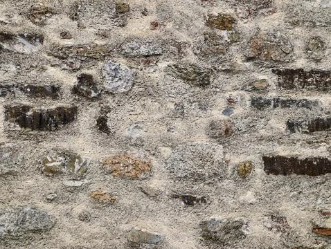 Weathered stone and mortar wall texture with irregular stones Stockfoto's