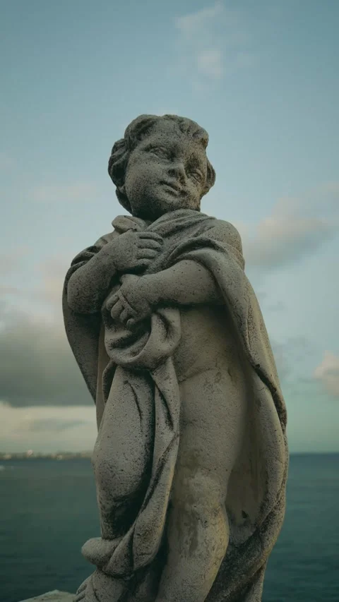 Weathered stone cherub statue by the sea Stock Footage 346264145
