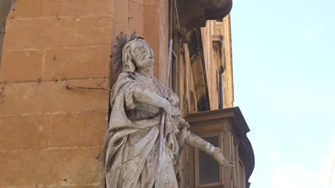 Weathered stone statue occupies a corner niche valletta historic building facade Stock Footage 341806945