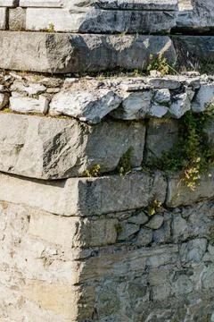 Weathered stone structure with green moss in sunny outdoor setting Stock Photos