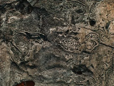 Weathered Stone Surface with Intricate Circular Carved Pattern, Natural Abs.. 스톡 사진