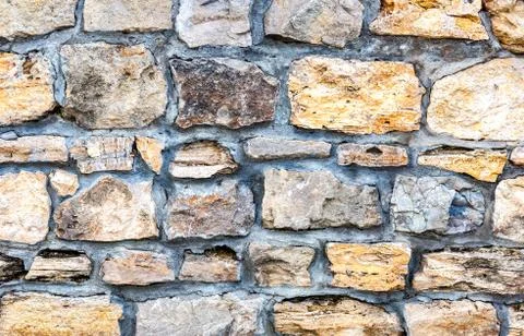Weathered stone wall as creative background texture Stock Photos