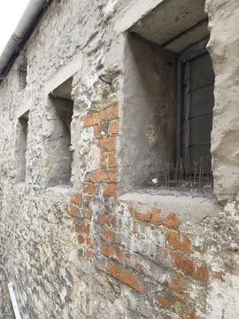 A weathered stone wall stitched with bricks and patched mortar Stock Photos