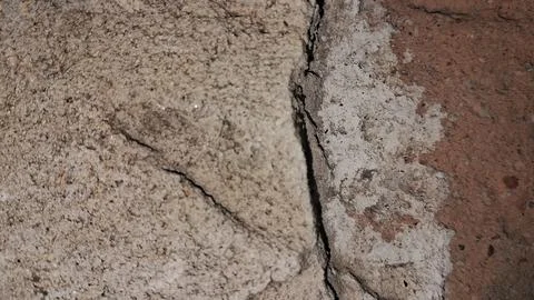 Weathered stone wall texture with a deep vertical structural crack Stock Photos