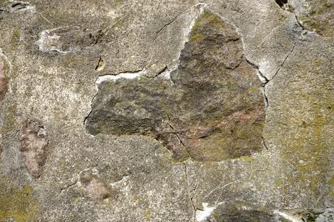 Weathered stone wall texture with moss and lichen growth 库存照片