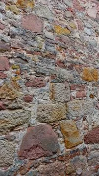 Weathered Stone Wall Texture Showcasing Varied Colors and Shapes in Daylight Stock Photos