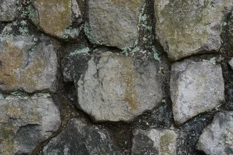 Weathered stones form a rugged, textured wall Stock Photos
