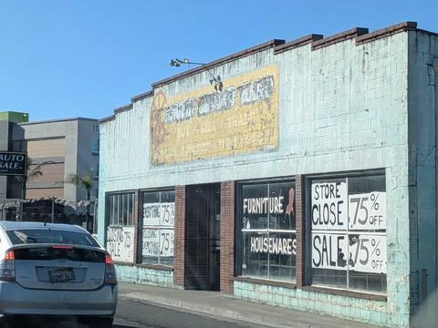 Weathered storefront with peeling paint and bold going-out-of-business 库存照片