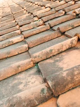 Weathered terracotta tiles line a rustic roof. 스톡 사진